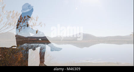 Immagine composita del hipster donna seduta sulla sua valigia Foto Stock