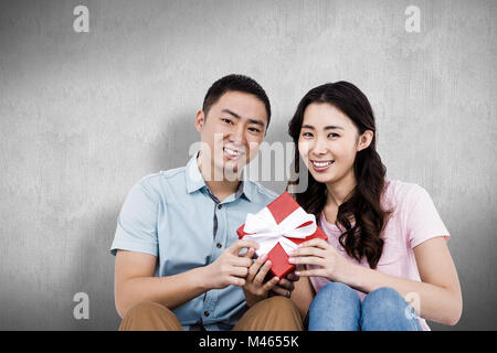Immagine composita della coppia felice azienda confezione regalo Foto Stock