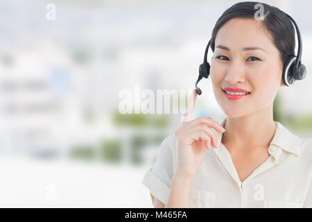 Immagine composita della bella donna sorridente executive con cuffia Foto Stock