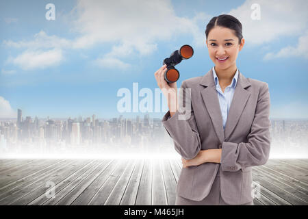 Immagine composita del ritratto di una imprenditrice tenendo il binocolo Foto Stock