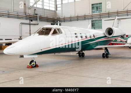 Piccole private jet aziendale in un hangar Foto Stock