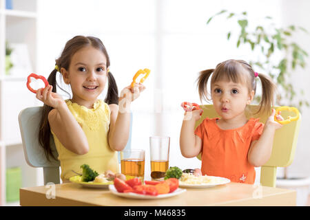 Contenti i bambini a mangiare cibi sani a scuola o a casa Foto Stock