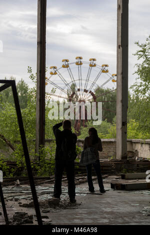 I turisti fotografare l'iconica ruota panoramica Ferris nella città di pripjat, Chernobyl, in Ucraina Foto Stock