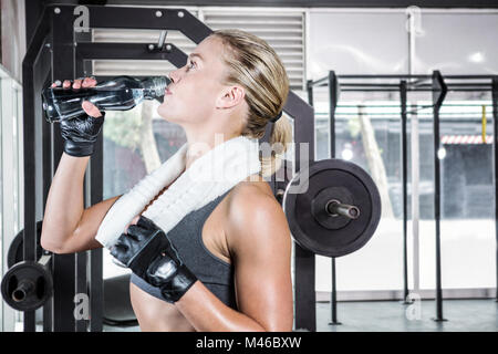 Immagine composita della donna muscolare acqua potabile Foto Stock