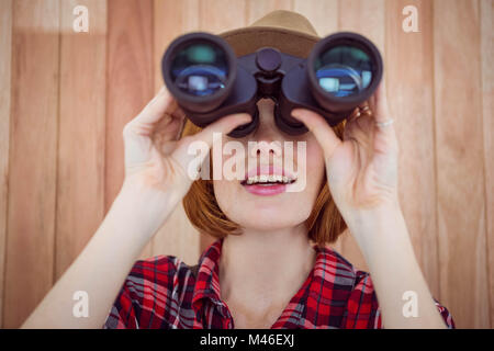 Tanga sorridente donna che guarda attraverso il binocolo Foto Stock