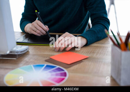 I progettisti di femmina mani scrivendo su un tavolo digitale Foto Stock