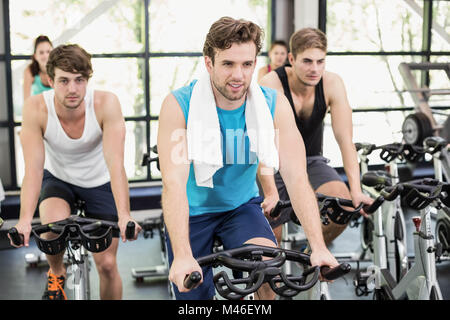 Montare il gruppo di persone che utilizzano la cyclette insieme Foto Stock