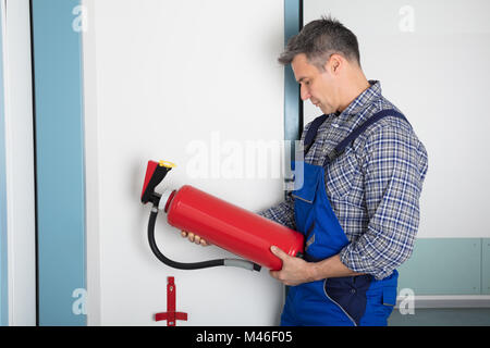 Maschio professionale di controllo della condizione di un estintore Foto Stock