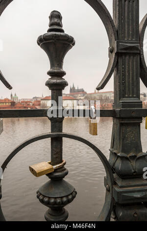 Vista del fiume Moldava e sul castello di Praga dall'altro lato del fiume attraverso la recinzione con amore si blocca Foto Stock