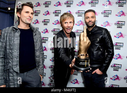 Matt Bellamy, Chris Wolstenholme e Dominic Howard dei Muse tenendo il premio per la miglior band internazionale di premi camera presso il VO5 NME Awards 2018 tenutasi presso l'O2 Brixton Academy di Londra. Foto Stock