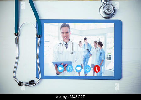 Immagine composita di sorridere medico tenendo tavoletta digitale Foto Stock