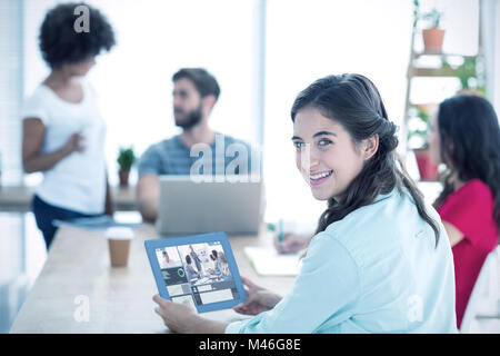 Immagine composita di sorridere imprenditrice utilizzando tablet Foto Stock