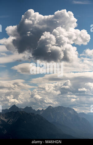 Grandi e soffici cumulus cloud sopra cime di montagna Foto Stock