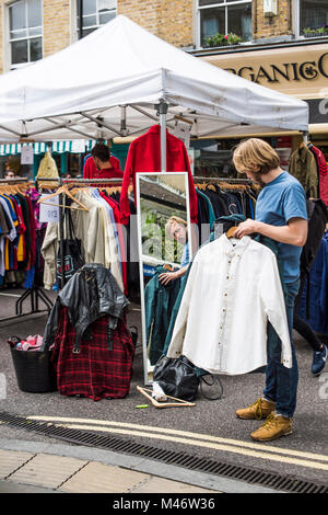 Hackney, East London, Regno Unito - 4 Agosto 2017: abbigliamento Vintage shopping al mercato di Broadway. Foto Stock