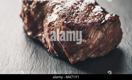 Bistecca di manzo da entrecote parte sulla scheda di ardesia Foto Stock