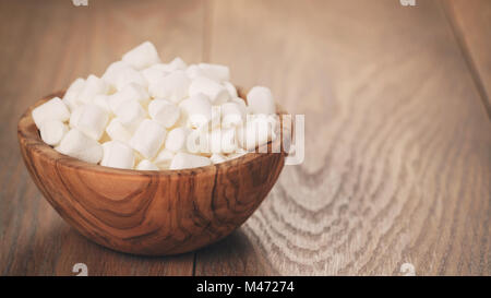 White marshmallows in ciotola di legno su tavola Foto Stock