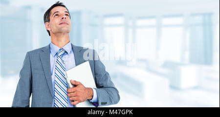 Immagine composita di entusiasti tifo imprenditore tenendo il suo computer portatile Foto Stock