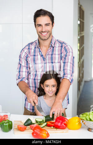 Ritratto di Padre Felice il taglio di vegetali con la figlia Foto Stock