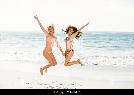 Bella entusiasti amici salto sulla spiaggia Foto Stock