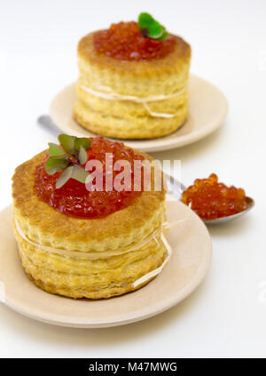 Tortine con caviale rosso su sfondo bianco. Foto Stock