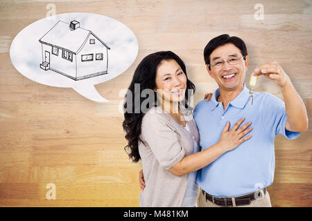 Immagine composita della coppia sorridente in possesso di un set di chiavi Foto Stock