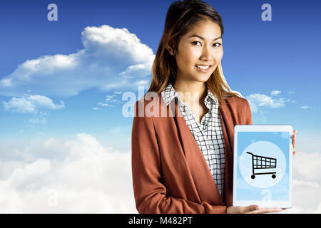 Immagine composita di sorridere imprenditrice che mostra un tablet Foto Stock