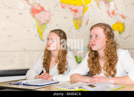 Due studentesse in aula con mondo grafico Foto Stock