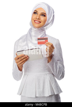 Donna musulmana con tablet PC e scheda di plastica isolato su bianco Foto Stock