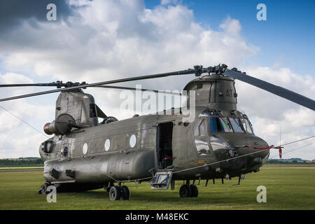 Royal Air Force Chinook HC2 seduto su un campo di aviazione di erba Foto Stock