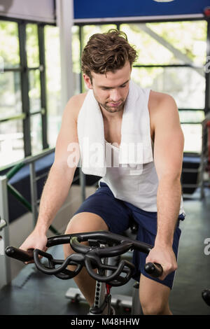 Uomo al lavoro su cyclette in classe di filatura Foto Stock