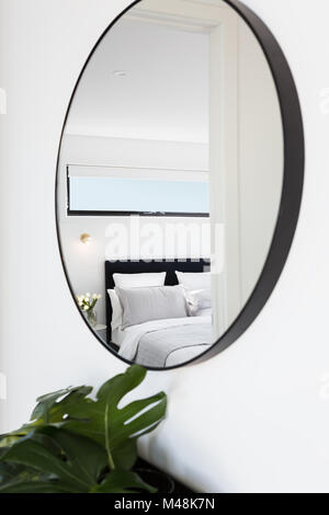 Vista di una camera da letto di lusso riflessa in uno specchio di corridoio Foto Stock
