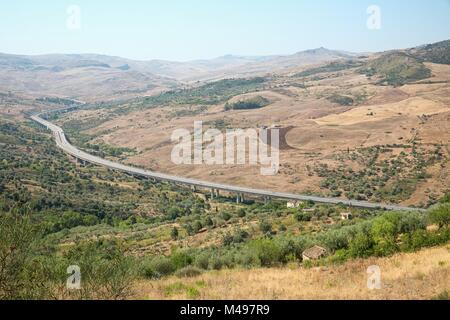 Paesaggio terrestre della Sicilia interna con autostrada nel giorno di estate Foto Stock