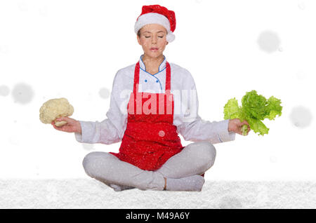 Cuocere in Santa hat, yoga, verdure sotto neve Foto Stock