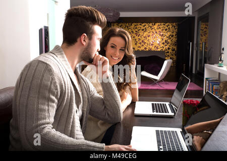 Coppia giovane guardando insieme alcuni contenuti su un computer portatile Foto Stock