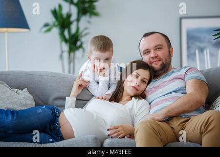 Foto di felice coppia sposata con il piccolo figlio sul divano Foto Stock