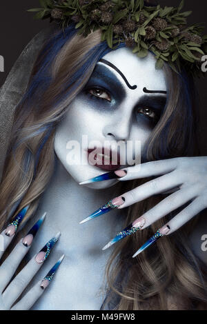 Ritratto di un orribile scary Corpse Bride a corona con fiori morti, Halloween trucco e manicure lungo.Design di chiodi Foto Stock