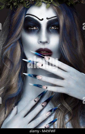 Ritratto di un orribile scary Corpse Bride a corona con fiori morti, Halloween trucco e manicure lungo.Design di chiodi Foto Stock