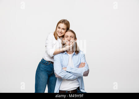 Felice fiducioso bruna giovane donna sorridente e toccando il suo fidanzato mento con l'amore. Foto Stock