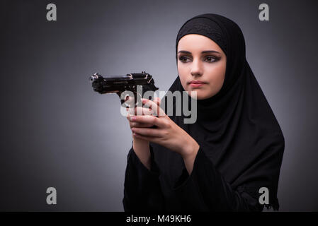 Donna musulmana in abito nero contro uno sfondo scuro Foto Stock