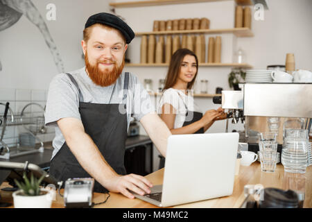 Caffè il concetto di Business - il giovane bello bartende barbuto, barista o manager che lavora e piallare in laptop alla moderna caffetteria. Foto Stock