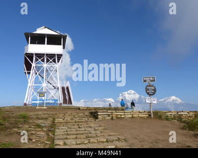 Torre di vedetta e turisti su Poon Hill - uno dei più visitati himalayana punti di vista in Nepal, in vista di Dhaulagiri gamma, Circuito di Annapurna Foto Stock