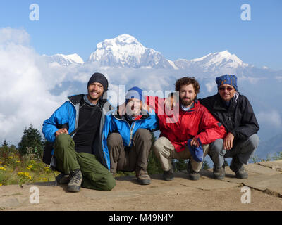 Felici gli escursionisti su Poon Hill, Dhaulagiri gamma sull'backround - uno dei più visitati himalayana punti di vista in Nepal, in vista di Snow capped Himalaya Foto Stock
