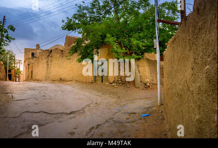 La strada del villaggio iraniano al tramonto, intorno sary pise-strutture murata Foto Stock