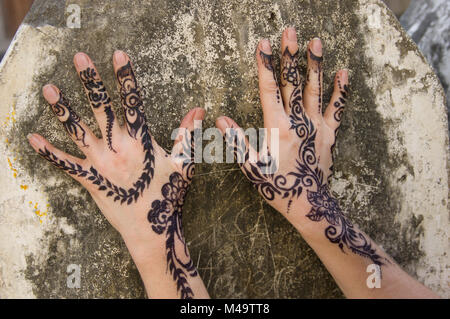 Donna di henna decorate le mani contro un muro di pietra nella città di pietra, Zanzibar, Tanzania in una luminosa e soleggiata giornata Foto Stock