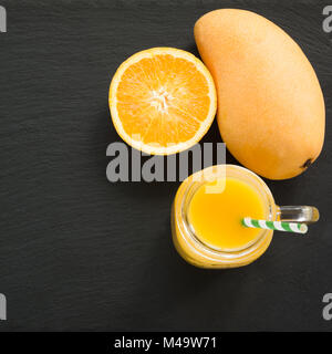 Mango fresco frutta e di arancione e nero ardesia piatto. Foto Stock