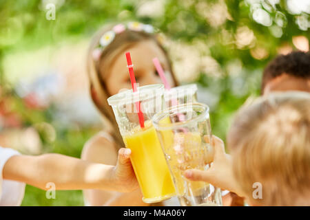 Bambini celebrare e toast con il succo su una festa di compleanno per bambini o parte Foto Stock