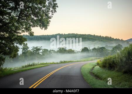 La laminazione di nebbia attraverso Blue Ridge Parkway terre di fattoria Foto Stock