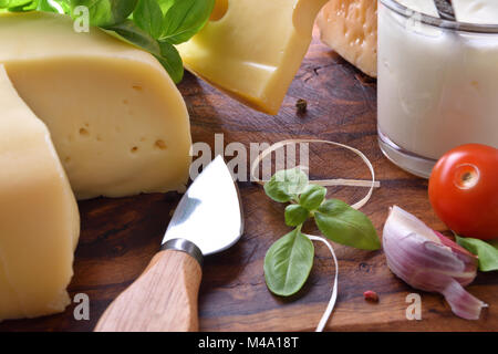 Assortimento di prodotti lattiero-caseari sul tagliere. Vista in elevazione. Composizione orizzontale Foto Stock