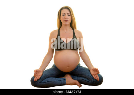 Yogini donna incinta è la pratica dello yoga mentre seduto isolato contro uno sfondo bianco. Foto Stock