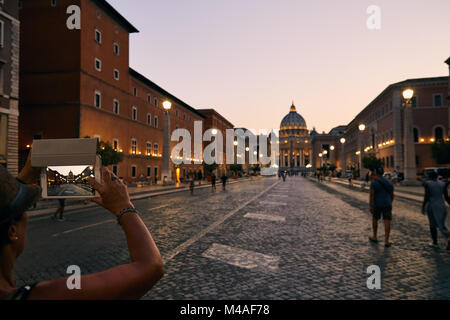 Roma - 4 agosto: turistico è di scattare le foto con il telefono cellulare della Basilica di San Pietro durante il crepuscolo con illuminazione il 4 agosto 2017 a Roma Italia Foto Stock